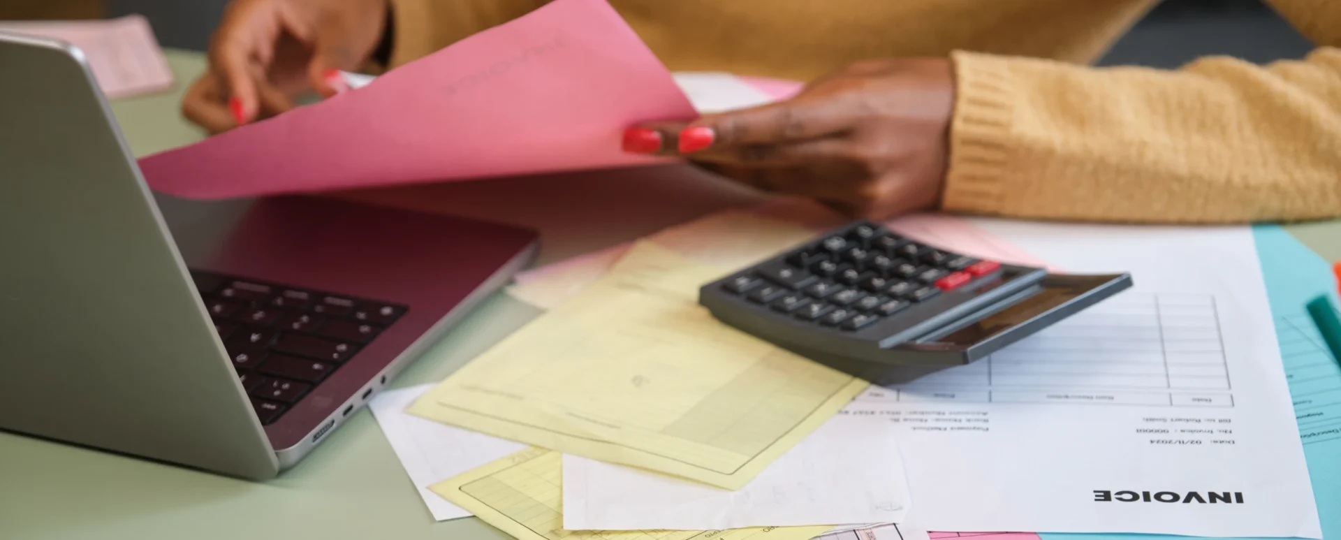Calculating expenses using a calculator and papers.